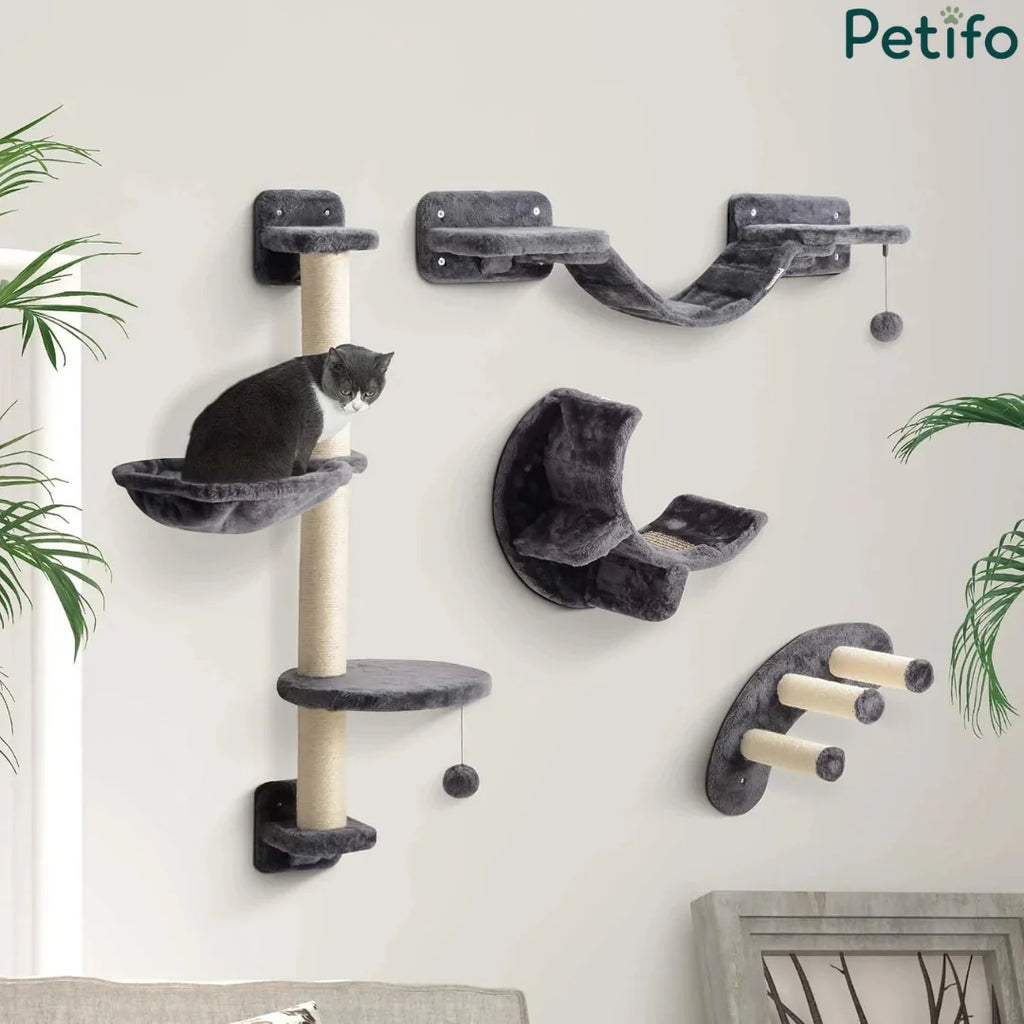 Black and white cat resting comfortably on a wall-mounted plush gray furniture collection inside a modern living room.